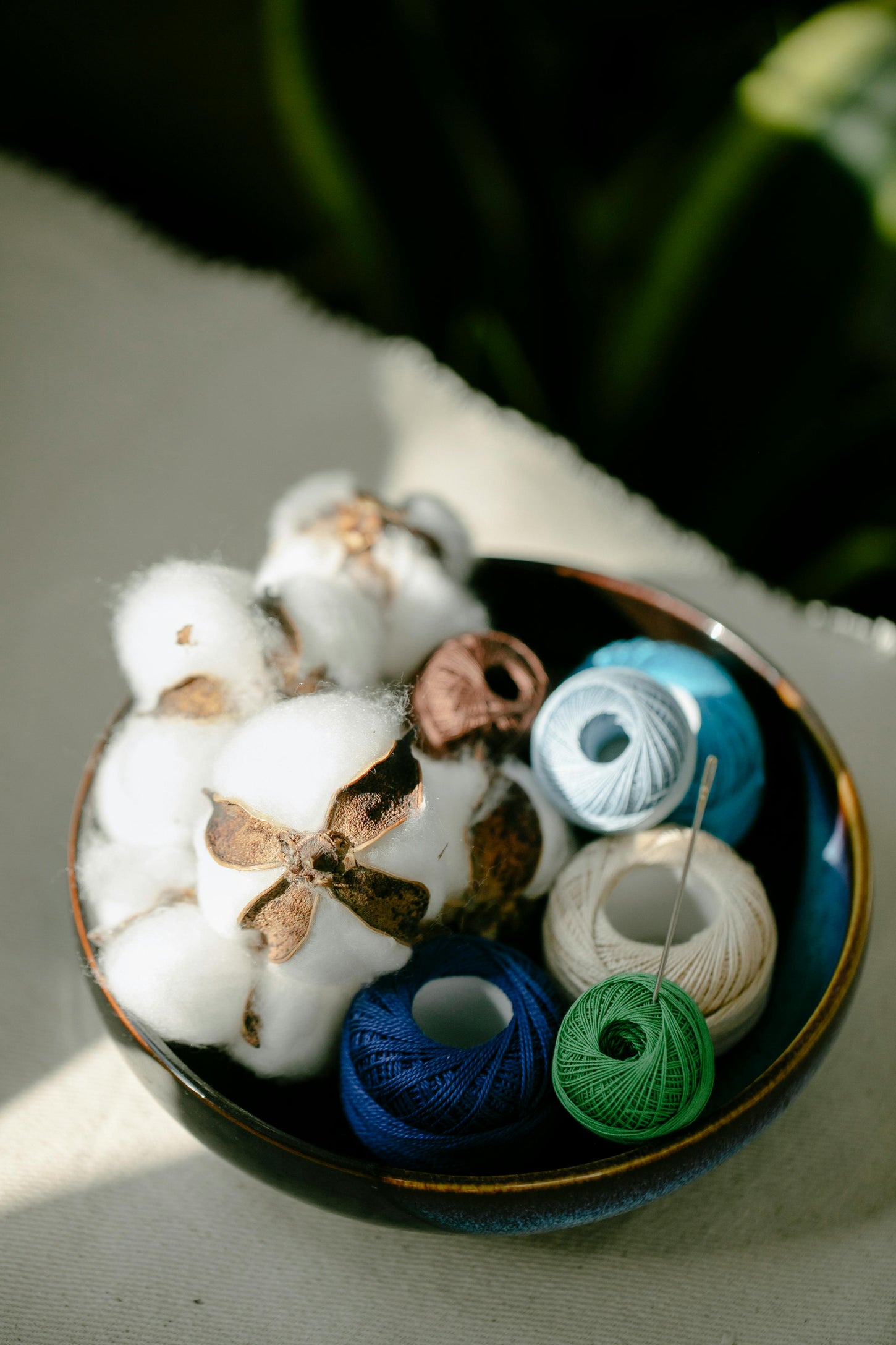 A luxurious bowl brimming with soft cotton balls and vibrant threads, perfect for elegant crafting and artistic endeavors